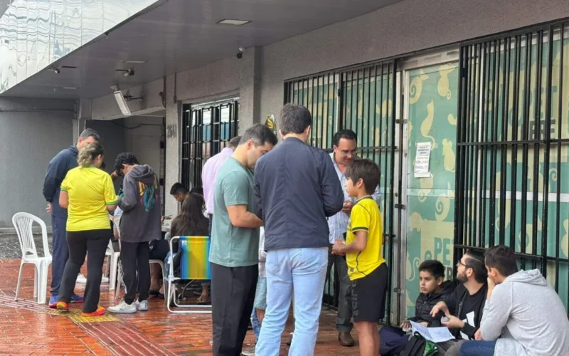 Nem chuva nem jogo do Brasil param crianças na troca de figurinhas
